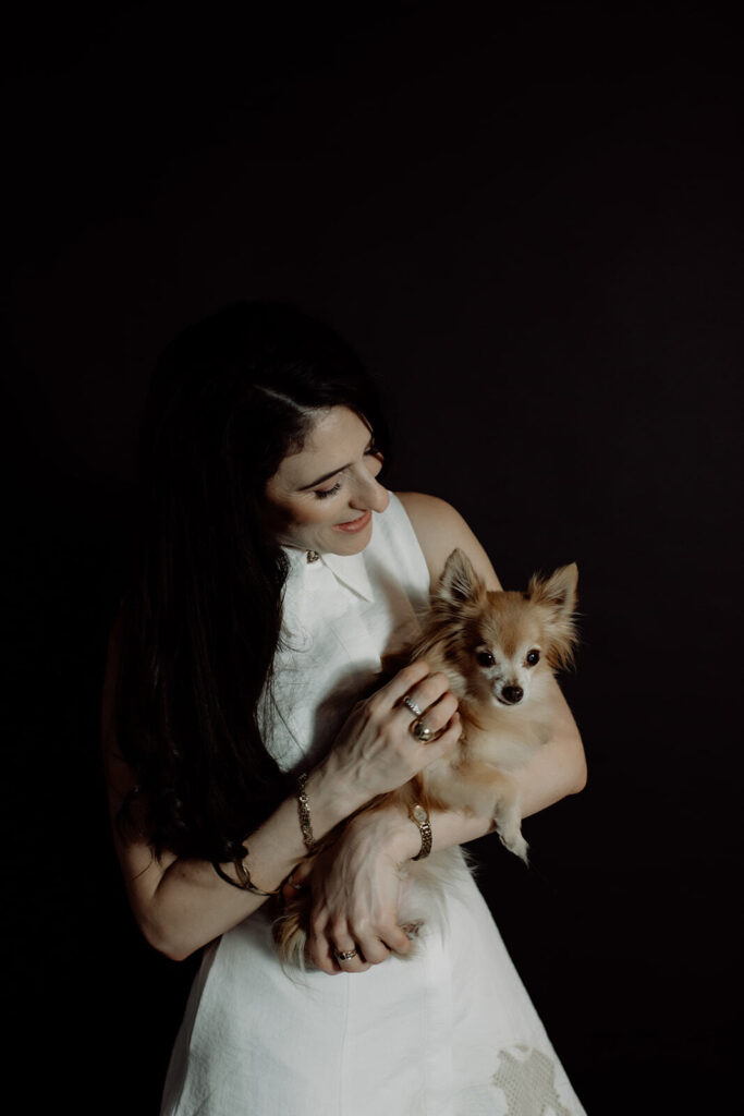 JodiPlumbley_Simmone-341_websize Simmone Helander looking down at her dog Millie in her arms