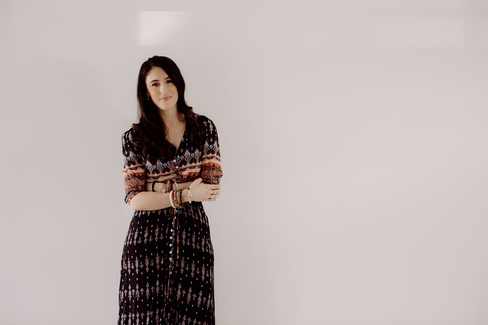 JodiPlumbley_Simmone-81_websize Simmone Helander standing with arms crossed in a patterned dress